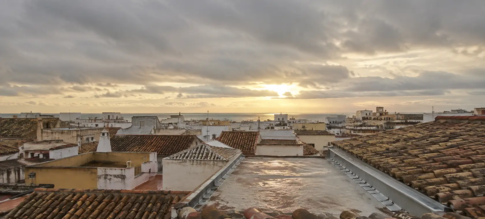 Panorama de tejados y azoteas de una población costera de Cádiz después de la lluvia al atardecer